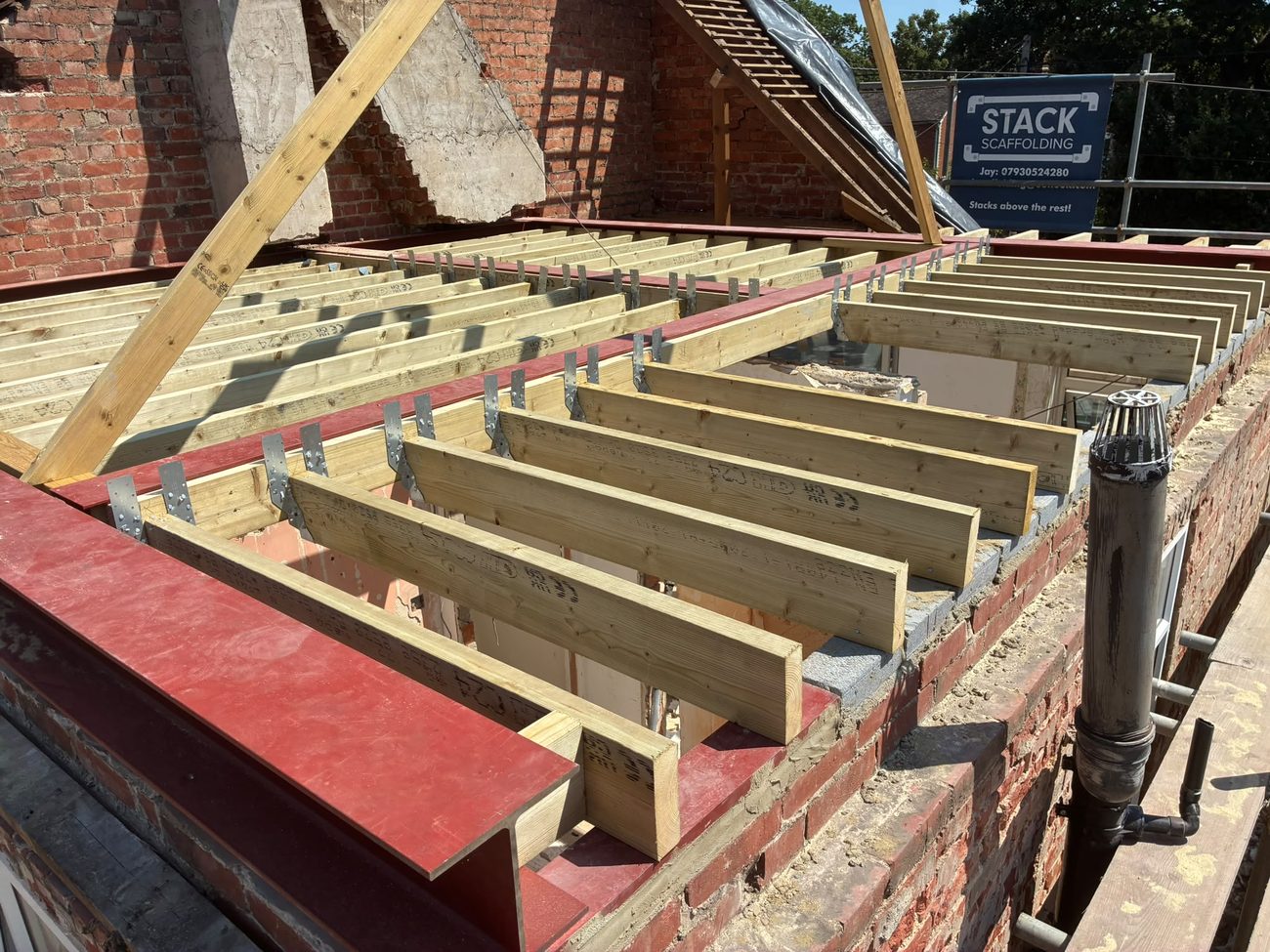 New floor joists seated in joist hangers on structural steelwork, forming the new floor of a loft conversion