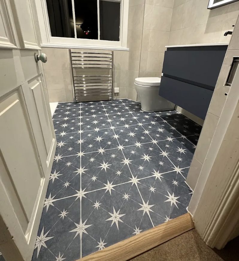 Cloakroom with a navy star-patterned floor, a wall-hung navy vanity and a chrome towel rail